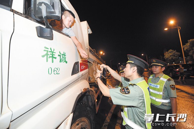 前晚至昨晨，在雨花区香樟路与曙光南路一处工地，城管渣土执法人员正在对渣土车进行检查。长沙晚报记者 黄启晴 摄