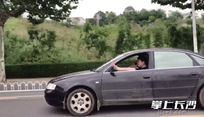 在潇湘大道，一名驾驶员边开车边打电话，还把一条腿伸出车窗外。 市民张女士 供图