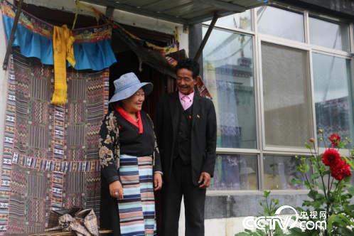 村民扎西多吉与妻子在新房子门口开心地交谈