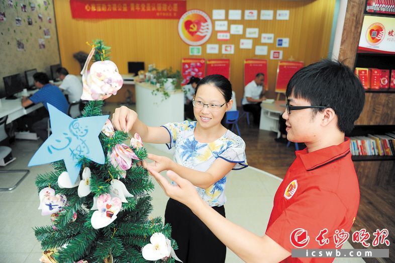 近日，天心区坡子街商圈流动党员在“流动党员心家园”的心愿树上认领辖区小朋友们许下的微心愿。