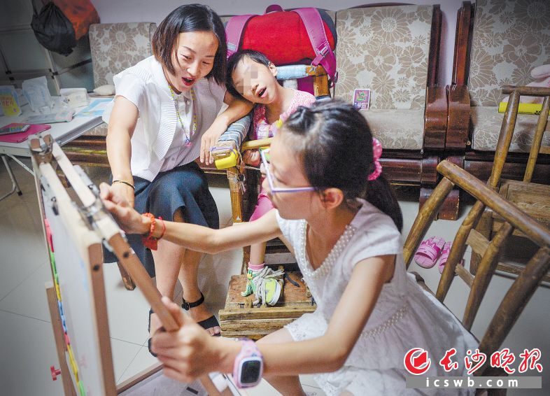 徐杨（左一）带着女儿彭夕（右一）给晨晨上开学第一课。长沙晚报记者 邹麟 摄