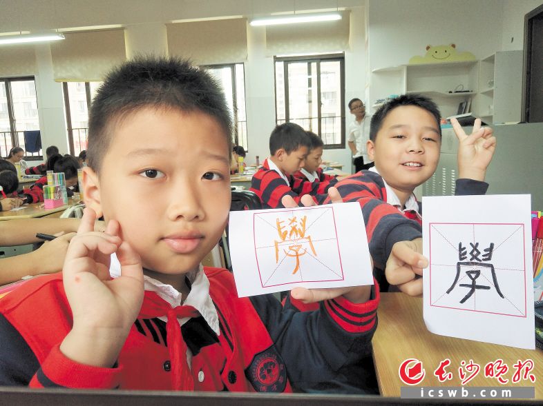 昨日，博才中海小学五年级的两名学生展示自己临摹的篆体“学”字。 长沙晚报记者 詹春华 摄