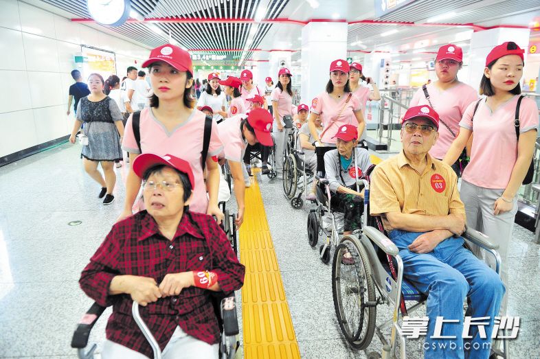 近日，开福区东风路街道砚瓦池社区组织30多名老人出门看长沙变化，老人们在志愿者一对一的陪护下乘坐地铁。长沙晚报记者 贺文兵 摄