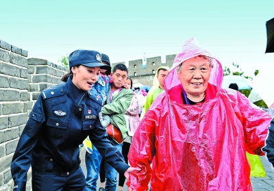 昨天,八达岭长城,民警在雨中帮助游客.傅祖兴摄