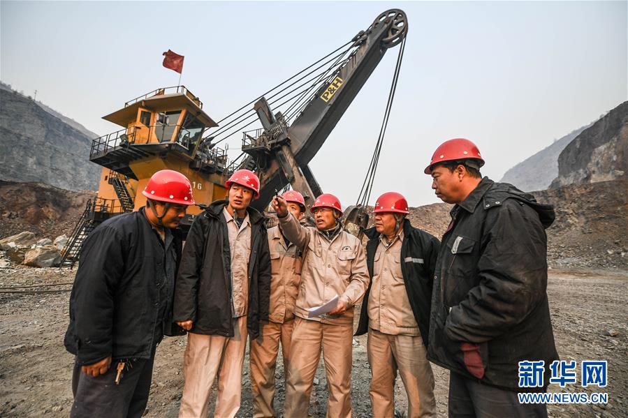 11月3日,郭明义(右三)在鞍钢矿业集团齐大山铁矿采场与工友交流制定