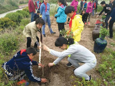 翁丽芬与孩子们一起植树