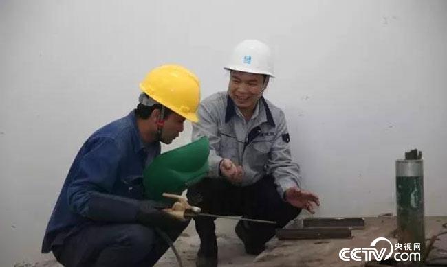 梁跃辉在指导焊工进行电焊操作
