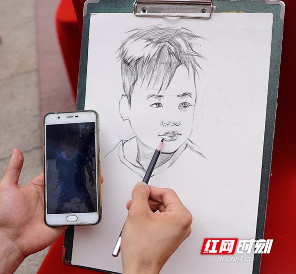 勤工俭学 湘南学院学生在街头画肖像画