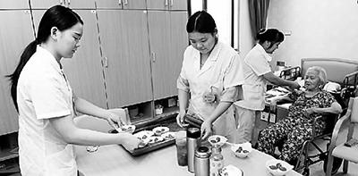6月24日，江西赣州市三康庙社区居家养老服务中心护理人员在为老人们分发水果。新华社发
