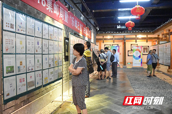 邮迷们仔细欣赏展出的邮票。.jpg