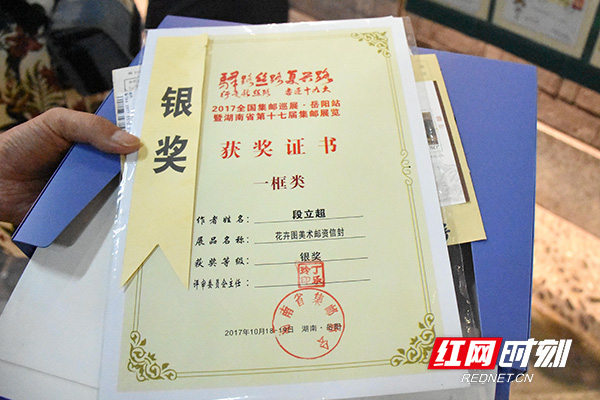 段立超展示着邮集获奖证书。.jpg