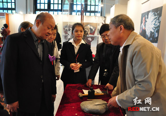 菊花石雕大师曹明珠正在为财团法人沈春池文教基金会副董事长严隽泰