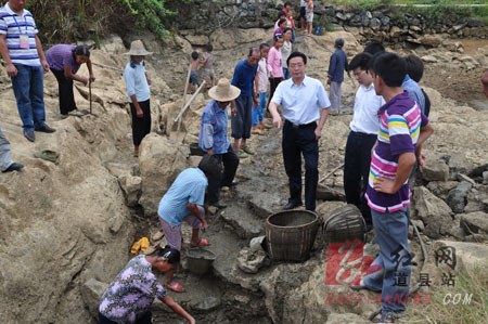 图为县委胡书记实地查看乐福堂乡甘塘坪村几近干涸的泉井.