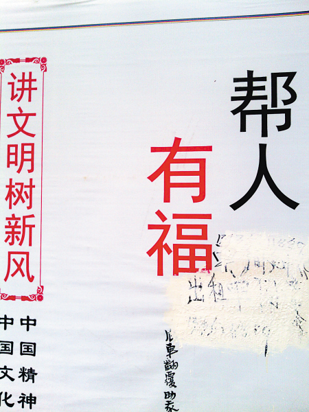 湘雅路旁,公益广告上被涂写"单间免中介"字样,旁边就是"讲文明树新风"