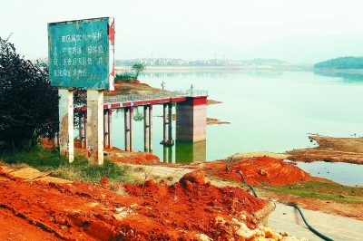 在斑驳的"库区属饮用水保护区……"的警示牌下,湘阴县燎原水库正在