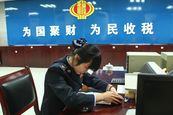 长沙县地税局服务大厅内,税务人员在一丝不苟地装订整理资料