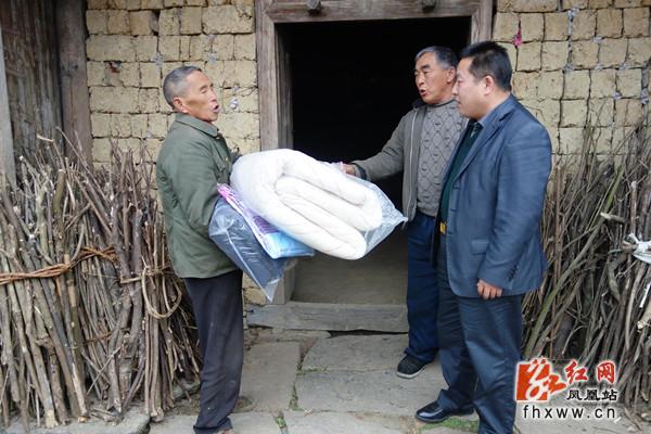 龙志平(右一)向特困户发放慰问物资