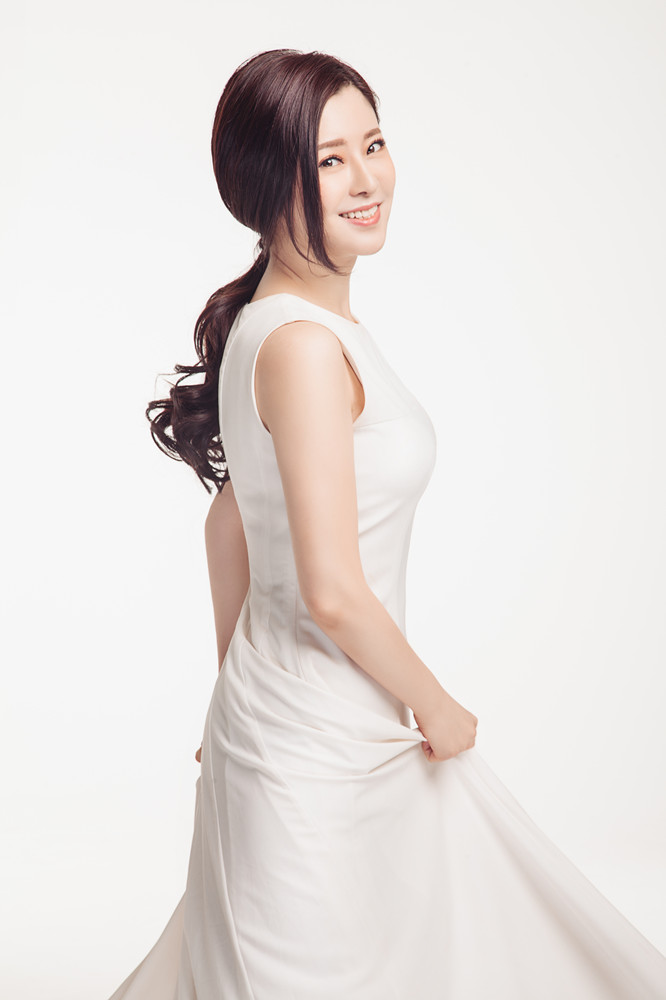 文静携素雅白衣出镜轻抚裙摆笑容迷人