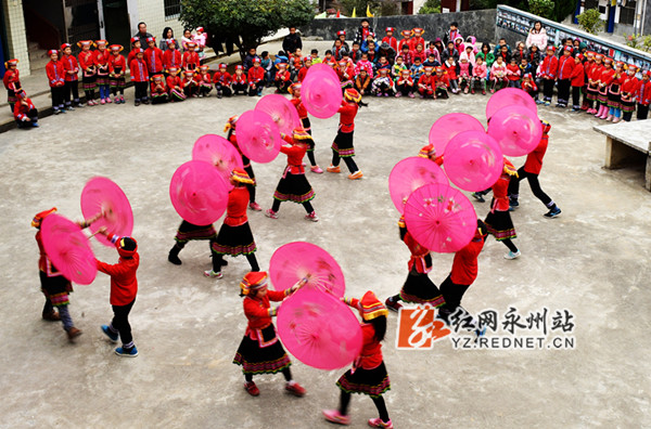 县汇源瑶族乡中心小学的学生们正在选修课中学习跳瑶族的竹竿舞,伞舞