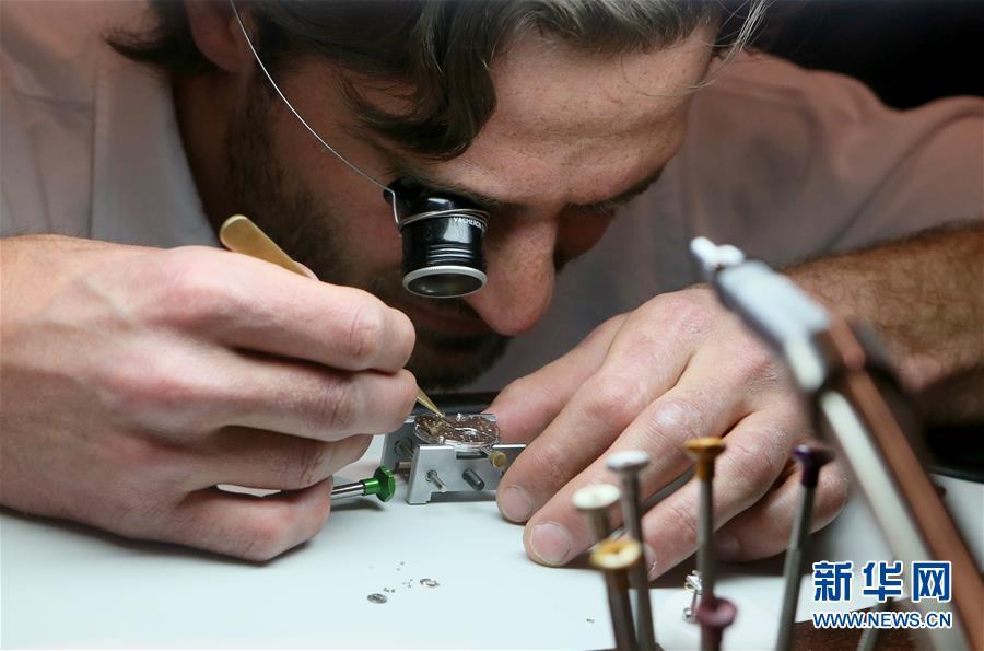 5月5日,在英国伦敦一家江诗丹顿精品店,一名参观者在体验手表制作工艺